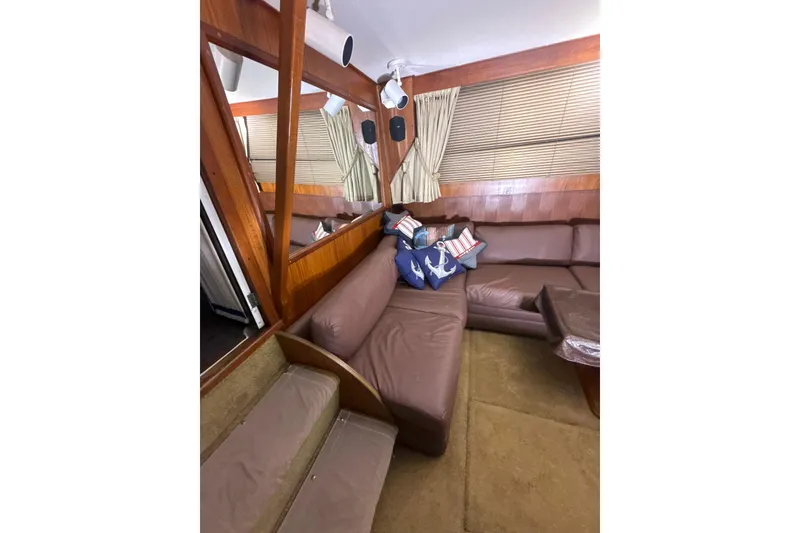 Slide: The Image of Interior of 1984 Viking 44 Motor Yacht with brown leather seating and nautical-themed pillows. - 94