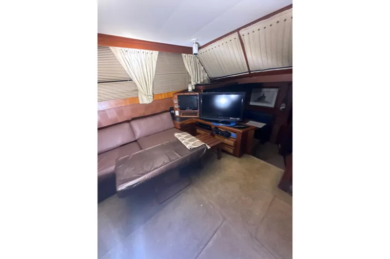 Slide: The Image of Interior of 1984 Viking 44 Motor Yacht with sofa, TV, and wooden accents. - 96