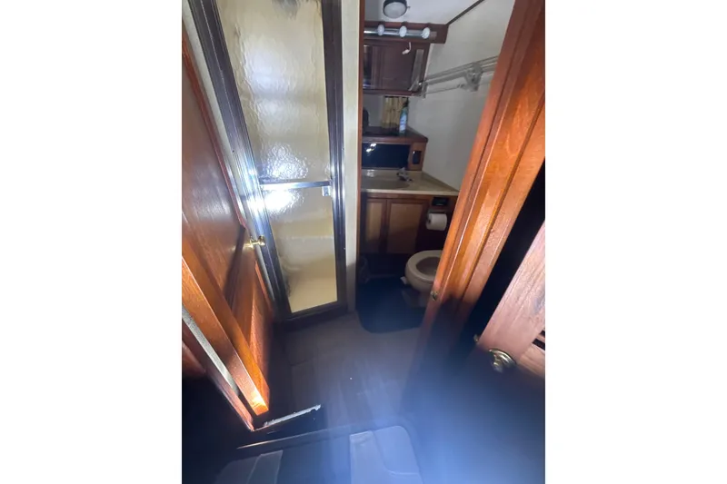 Slide: The Image of Bathroom interior of 1984 Viking 44 Motor Yacht with shower and wooden cabinetry. - 99