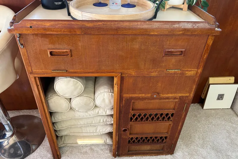 Slide: The Image of 1981 Ocean Alexander 50 Pilothouse interior with wooden cabinet and neatly stacked cushions. - 10
