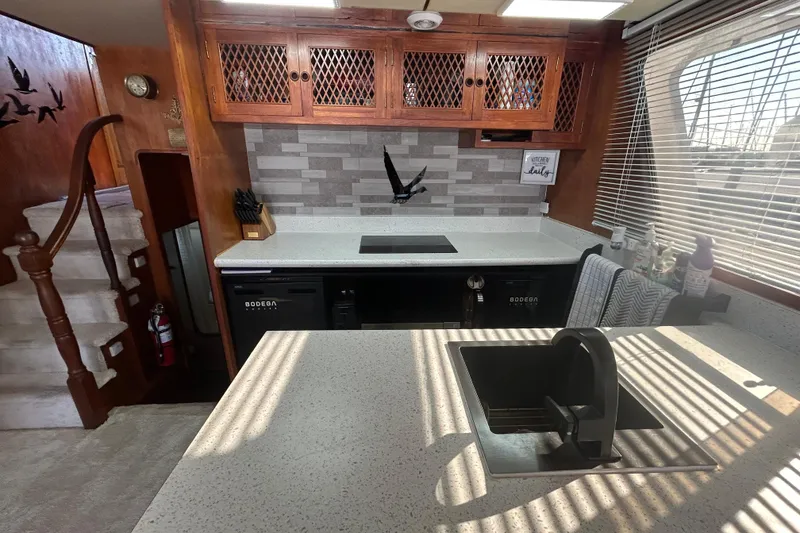 Slide: The Image of 1981 Ocean Alexander 50 Pilothouse kitchen with modern countertops and wooden cabinetry. - 13