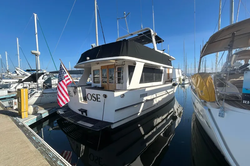 Slide: The Image of 1981 Ocean Alexander 50 Pilothouse yacht docked in marina, displaying American flag. - 2