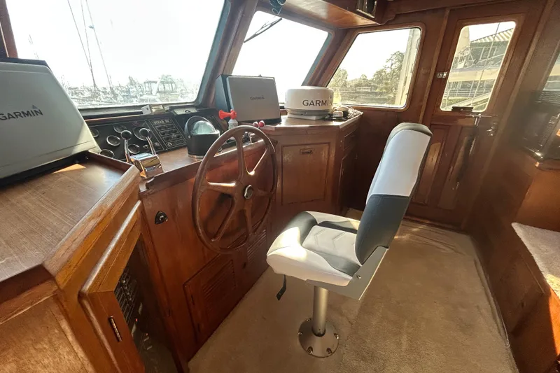 Slide: The Image of 1981 Ocean Alexander 50 Pilothouse interior with steering wheel and Garmin navigation equipment. - 26