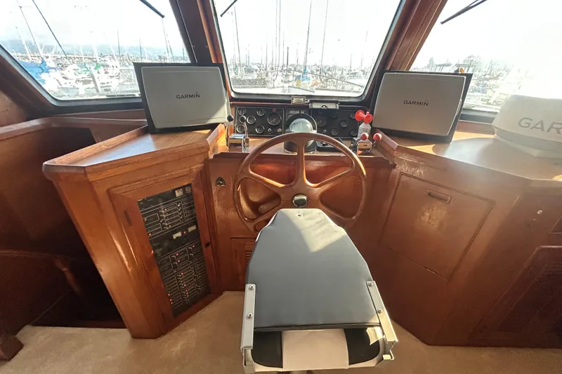 Slide: The Image of 1981 Ocean Alexander 50 Pilothouse helm with Garmin navigation displays and wooden steering wheel. - 28