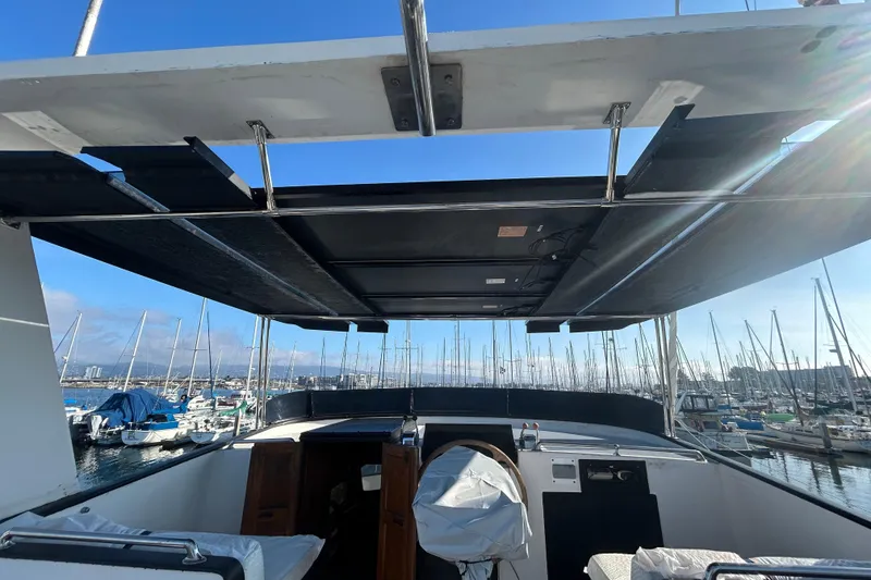 Slide: The Image of 1981 Ocean Alexander 50 Pilothouse yacht at marina, view of helm and canopy. - 31