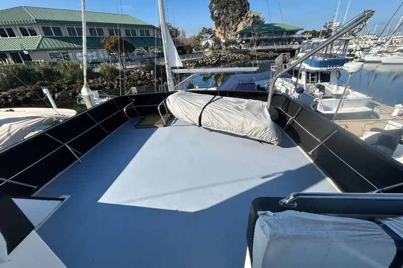 Slide: The Image of 1981 Ocean Alexander 50 Pilothouse yacht deck at marina, covered equipment, clear sky. - 32
