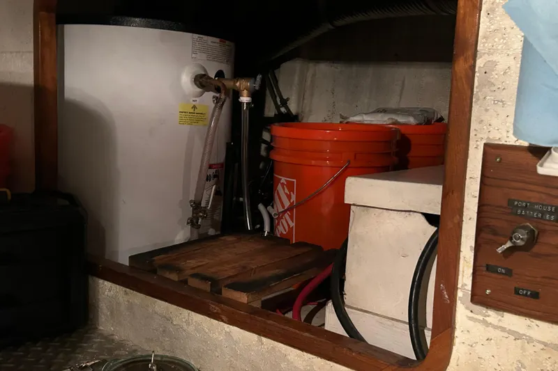 Slide: The Image of Engine room of 1981 Ocean Alexander 50 Pilothouse with water heater and storage buckets. - 39