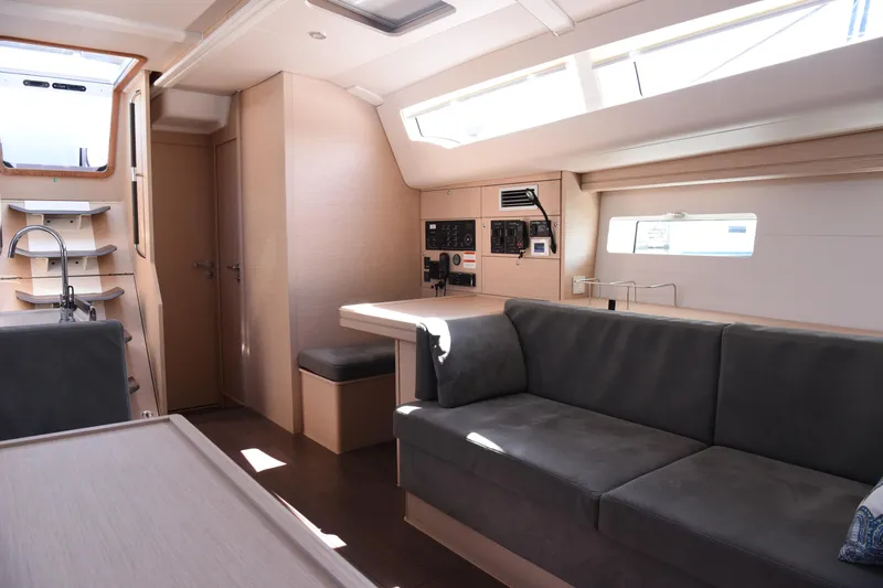 Slide: The Image of 2019 Jeanneau 51 yacht interior with modern design, featuring a cozy seating area and sleek kitchen. - 12