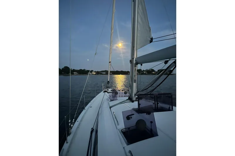 Slide: The Image of Sailing on a 2019 Jeanneau 51 yacht at sunset, calm waters reflecting moonlight. - 18