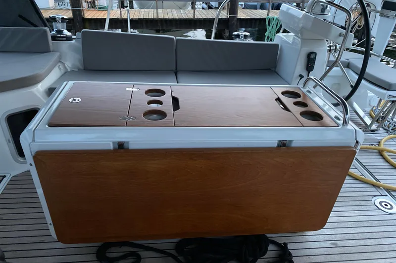 Slide: The Image of 2019 Jeanneau 51 yacht cockpit with wooden table and seating area. - 2