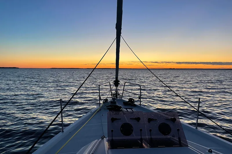 Slide: The Image of Sailing on a 2019 Jeanneau 51 yacht at sunset over calm waters. - 21
