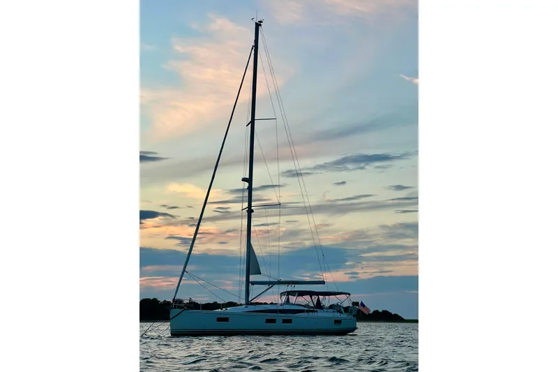 Slide: The Image of 2019 Jeanneau 51 sailboat at sunset on calm waters. - 22