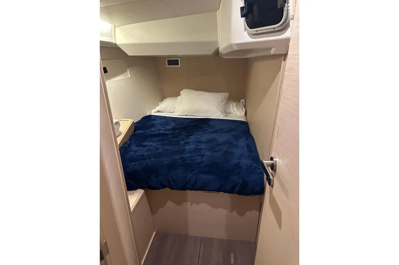 Slide: The Image of Cozy cabin interior of 2019 Jeanneau 51 yacht with blue bedding. - 25