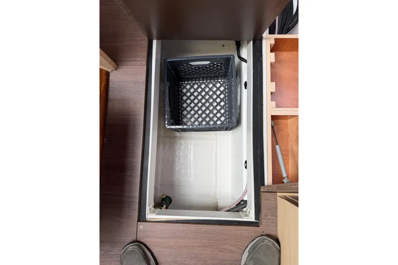 Slide: The Image of Storage compartment on Jeanneau 51 yacht, 2019 model, with a black crate inside. - 57