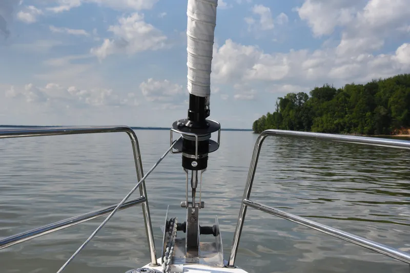 Slide: The Image of Bow view of a 2019 Jeanneau 51 sailboat on calm waters under a cloudy sky. - 7