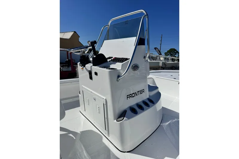 Slide: The Image of 2026 Frontier 2104 boat console with steering wheel and controls, in a marina setting. - 10