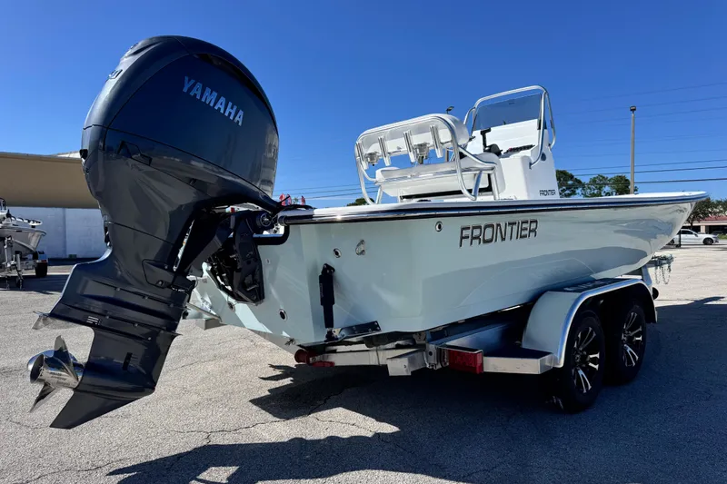 Slide: The Image of 2026 Frontier 2104 boat with Yamaha outboard motor on a trailer, parked outdoors. - 5
