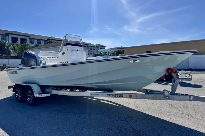 Slide: The Image of 2026 Frontier 2104 boat on trailer under clear blue sky. - 7