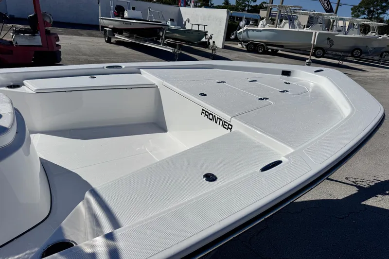 Slide: The Image of 2026 Frontier 2104 boat deck, spacious and sleek design, in a marina setting. - 8