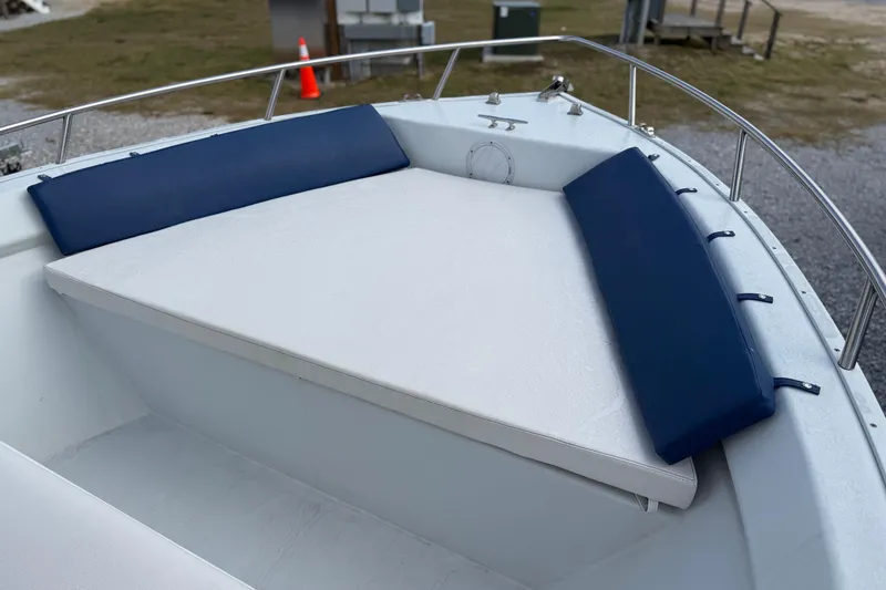 Slide: The Image of 1998 Cape Horn 19 CC boat with cushioned seating area, featuring blue and white upholstery. - 10