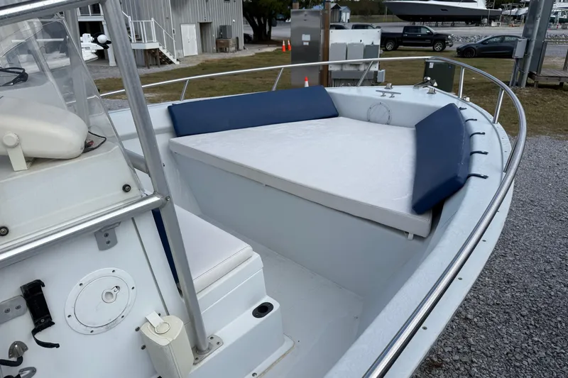 Slide: The Image of 1998 Cape Horn 19 CC boat with cushioned seating and railing, docked on gravel. - 11