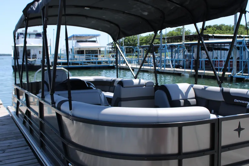 Slide: The Image of 2024 Berkshire 24CL CTS pontoon boat docked at marina, featuring spacious seating. - 6