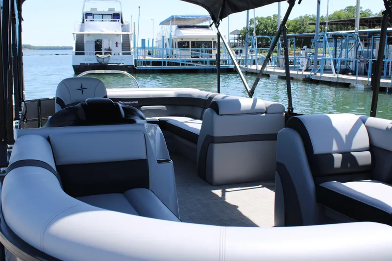 Slide: The Image of 2024 Berkshire 24CL CTS pontoon boat interior at marina, featuring spacious seating. - 7