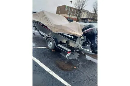 Slide: The Image of 2004 Tracker Targa 17 WT boat covered in a parking lot on a rainy day. - 5
