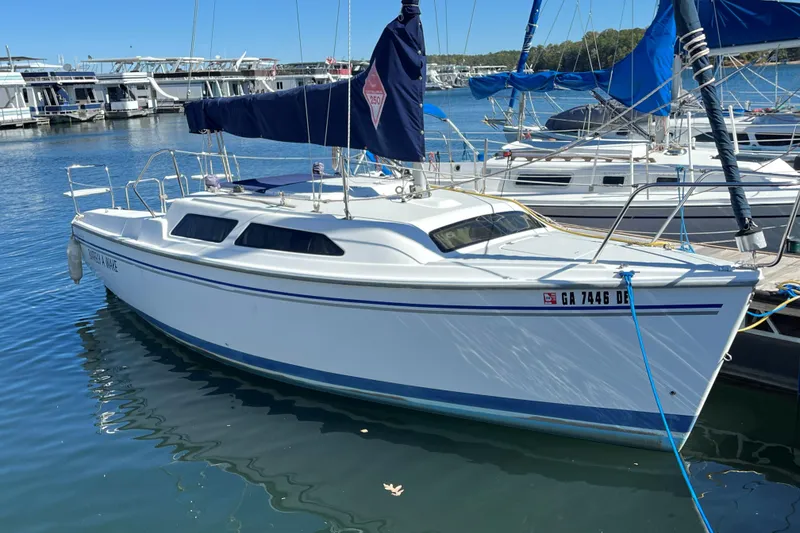 The Image of 2004 Catalina 250 WK sailboat docked in a marina, featuring a sleek white hull. - 0