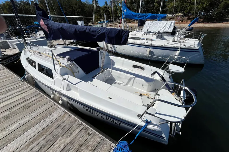 Slide: The Image of 2004 Catalina 250 WK sailboat docked at marina, featuring sleek design and spacious deck. - 3