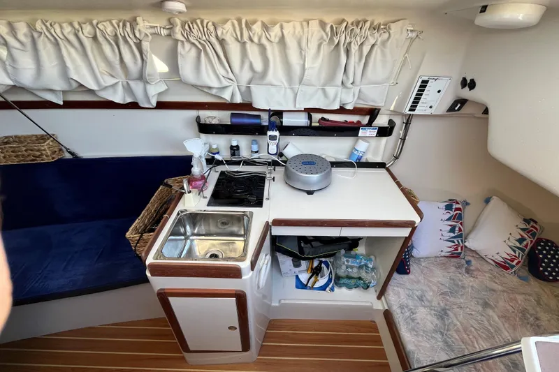 Slide: The Image of Interior of 2004 Catalina 250 WK sailboat with kitchenette and cozy seating area. - 5