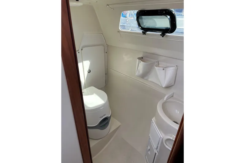 Slide: The Image of Compact bathroom in 2004 Catalina 250 WK sailboat with toilet, sink, and storage. - 7