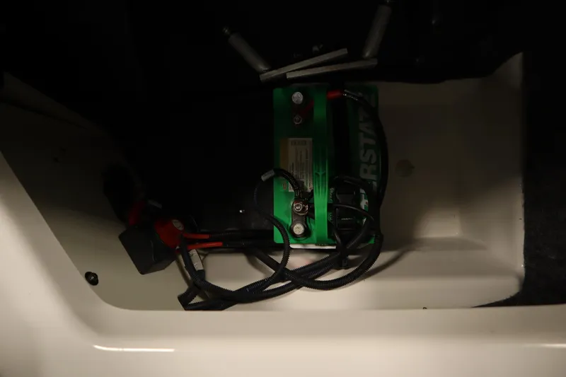 Slide: The Image of Battery compartment of a 2020 Yamaha Boats AR210, featuring a green battery. - 37