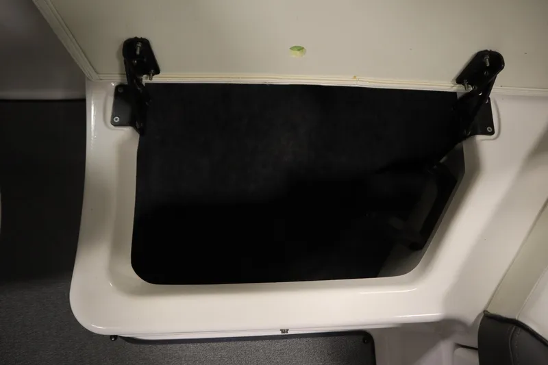 Slide: The Image of Storage compartment in 2020 Yamaha AR210 boat, featuring a hinged lid and black interior. - 40