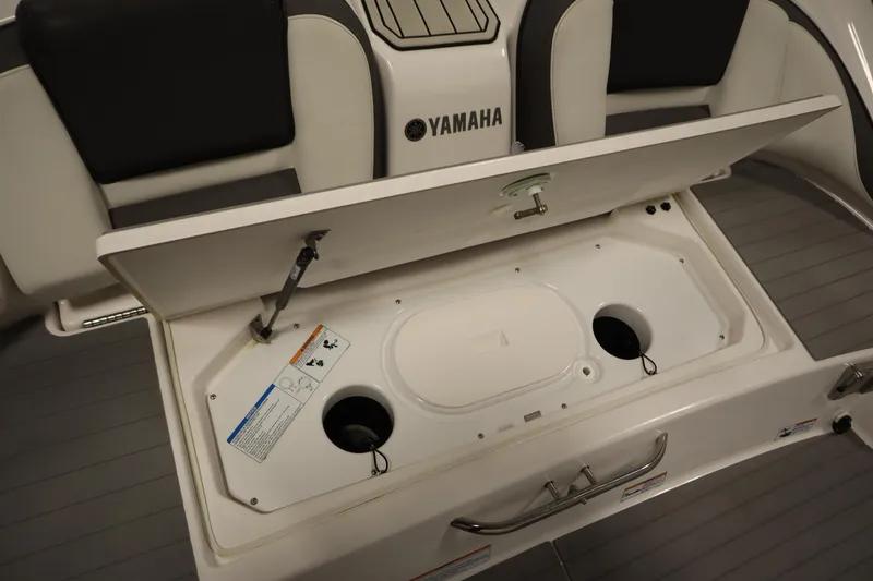 Slide: The Image of 2020 Yamaha AR210 boat storage compartment with open lid, showcasing interior details. - 43