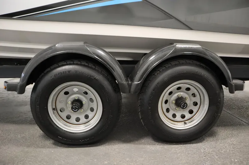 Slide: The Image of Trailer wheels of a 2020 Yamaha Boats AR210, featuring dual axles and fenders. - 49