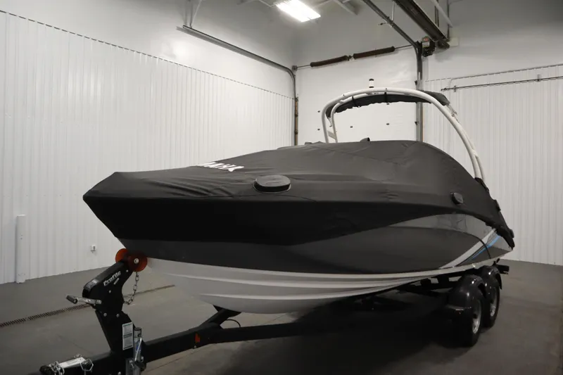 Slide: The Image of 2020 Yamaha Boats AR210 covered in a garage, on a trailer. - 50