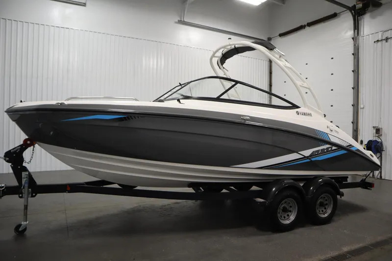 Slide: The Image of 2020 Yamaha AR210 boat in showroom, sleek design with blue accents on trailer. - 7