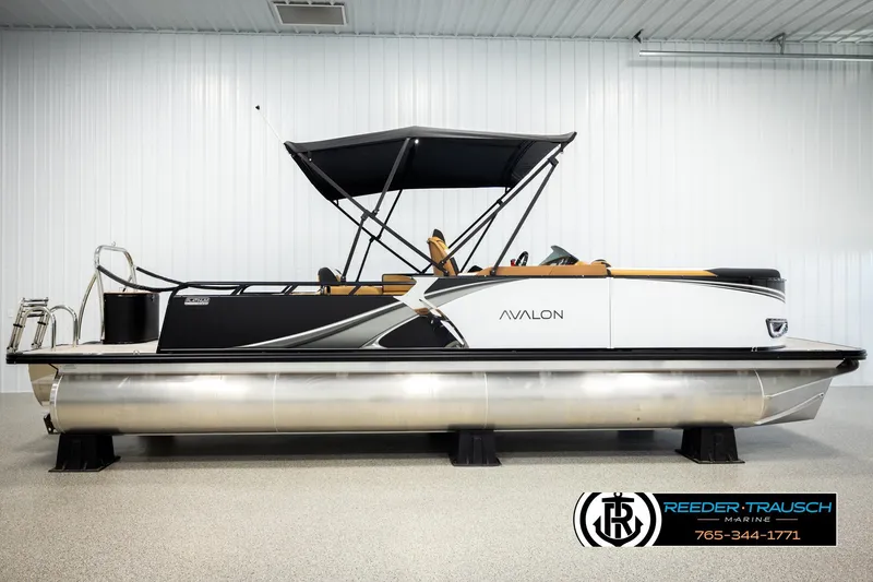 Slide: The Image of 2026 Avalon LSZ VRB pontoon boat in showroom with canopy and sleek design. - 5