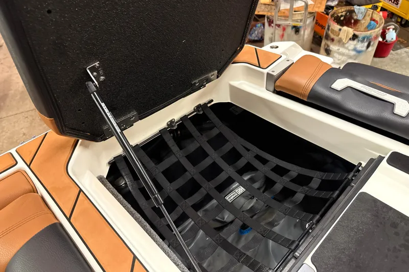 Slide: The Image of 2022 Malibu Wakesetter 25 LSV storage compartment with open lid and netting. - 17