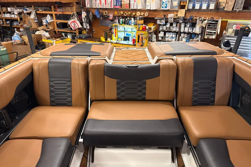 Slide: The Image of 2022 Malibu Wakesetter 25 LSV interior with tan and black seating in a workshop. - 22
