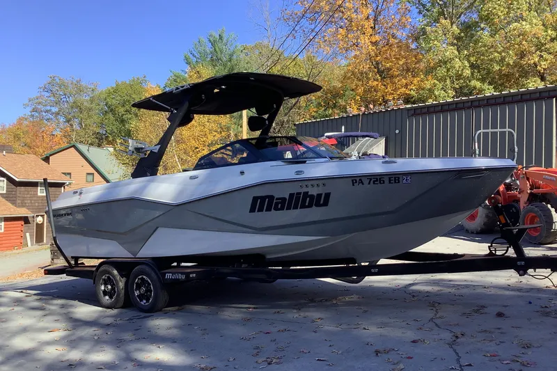 Slide: The Image of 2022 Malibu Wakesetter 25 LSV boat on trailer, parked outdoors in autumn setting. - 5