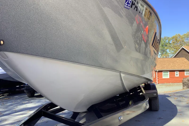 Slide: The Image of 2022 Malibu Wakesetter 25 LSV boat on trailer, parked near a red cabin. - 7