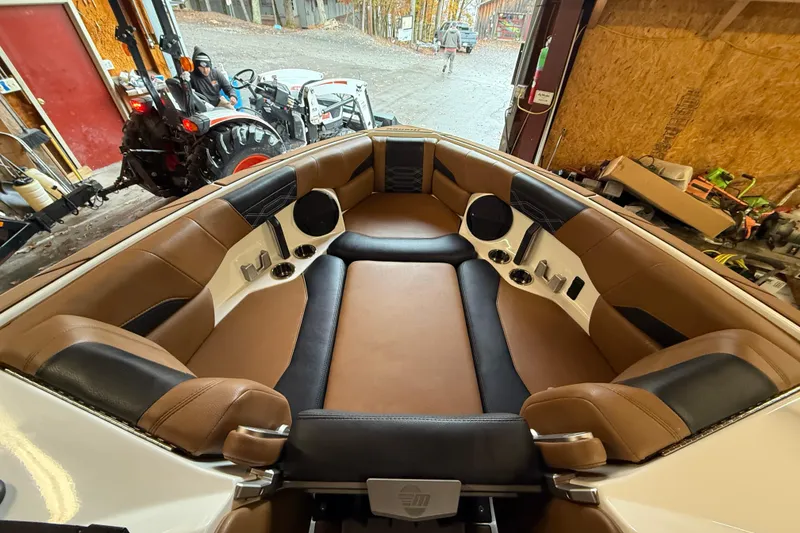 Slide: The Image of 2022 Malibu Wakesetter 25 LSV interior with brown and black seating in a garage setting. - 8