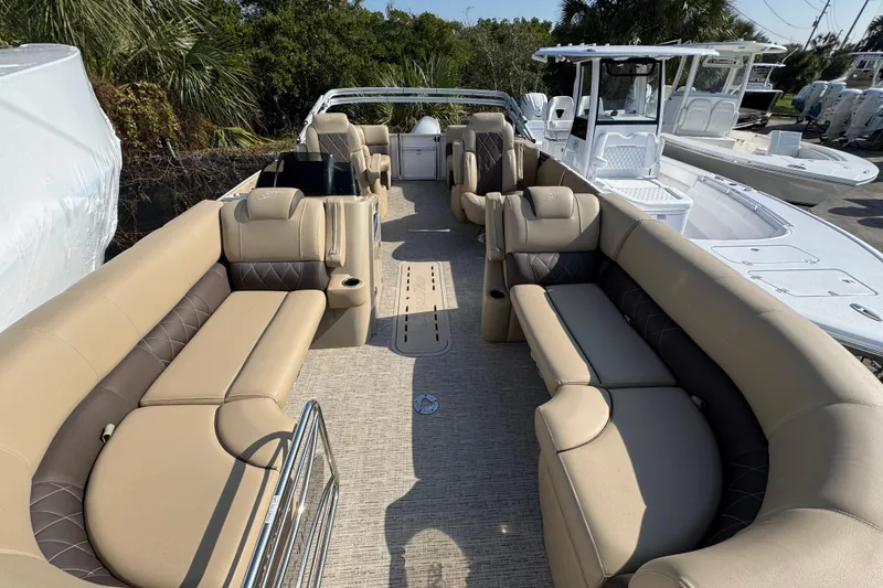 Slide: The Image of 2022 Blue Wave Pontoon boat with outboard motor, parked near a building. - 2