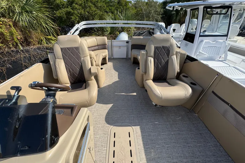 Slide: The Image of 2022 Blue Wave Pontoon boat displayed outside a marine dealership under a clear blue sky. - 3