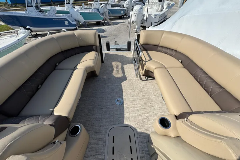 Slide: The Image of 2022 Blue Wave Pontoon boat interior with beige seating and cup holders. - 7