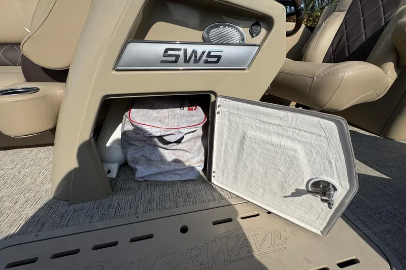 Slide: The Image of 2022 Blue Wave Pontoon boat interior with beige seating and cup holders. - 9