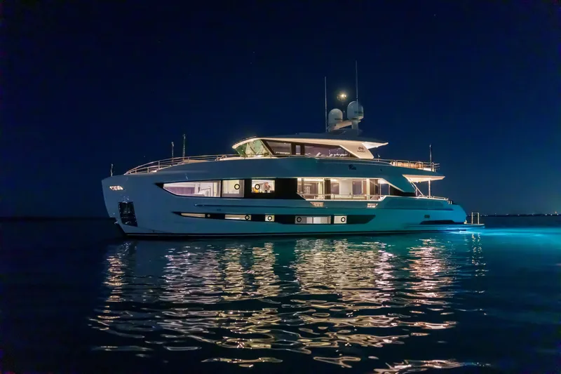 Slide: The Image of Luxurious 2023 Horizon FD90 yacht illuminated at night on calm waters. - 14