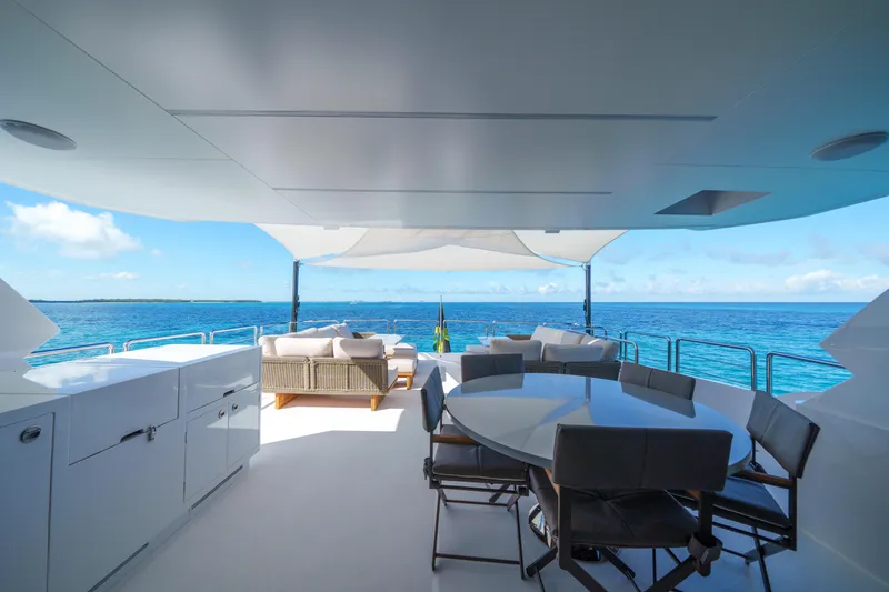 Slide: The Image of Luxurious Horizon FD90 yacht deck with ocean view, featuring modern seating and dining area, 2023 model. - 26